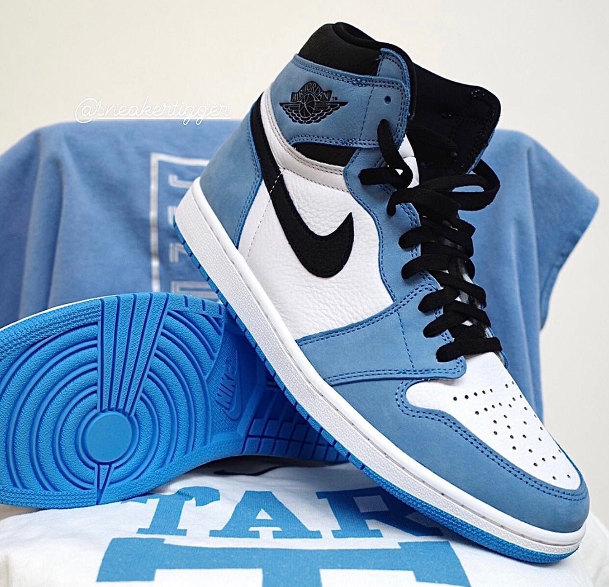 a pair of blue and white sneakers sitting on top of a t - shirt