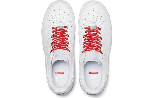 a pair of white sneakers with red laces