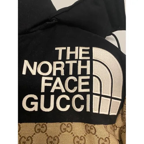 a black and white jacket with the north face logo on it